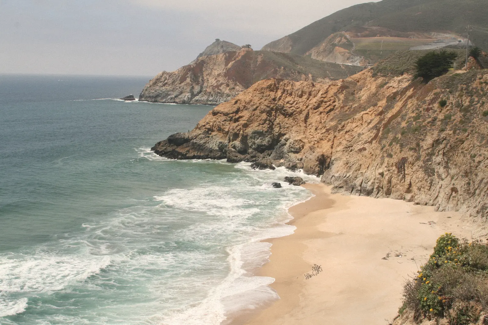 Photo of cliffs, a sandy cove and surf along the coast south of Pacifica